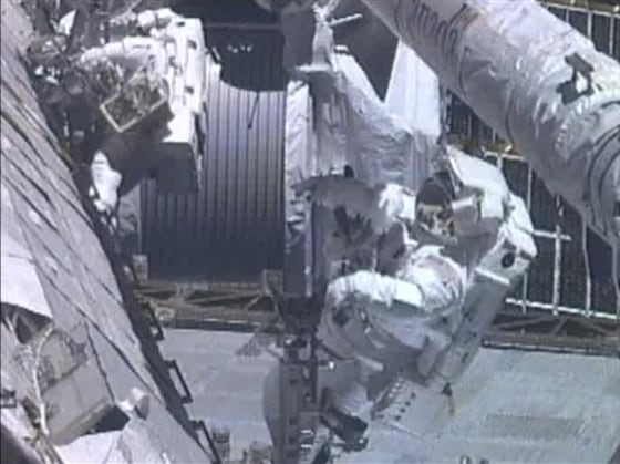 In this image from NASA TV, astronauts Greg Chamitoff (foreground) and Mike Fincke work outside the International Space Station repositioning the shuttle's Orbiter Boom Sensor System during the mission's fourth and final spacewalk Friday.